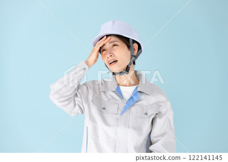 Woman, work clothes, helmet, headache Woman, work clothes, helmet, headache 122141145