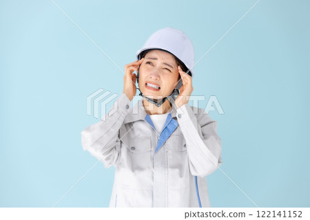 Woman, work clothes, helmet, headache 122141152