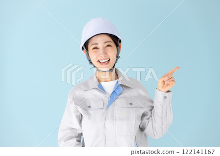 Woman, work clothes, helmet, pointing Woman, work clothes, helmet, pointing 122141167