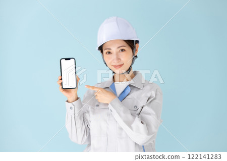Woman, work clothes, helmet, smartphone 122141283