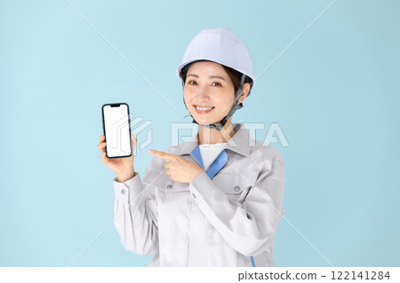 Woman, work clothes, helmet, smartphone Woman, work clothes, helmet, smartphone 122141284