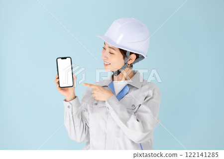 Woman, work clothes, helmet, smartphone 122141285