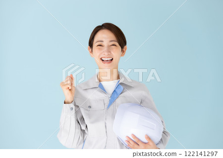 Woman, work clothes, helmet, fist pump Woman, work clothes, helmet, fist pump 122141297