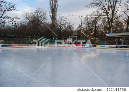Evening skating rink without people. Weekend evening, people are waiting for the ice to be rubbed on the skating rink. 122141766