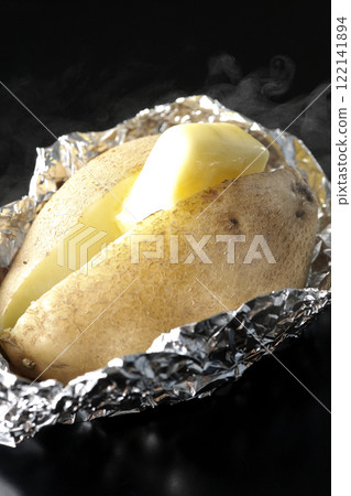 Hot buttered potatoes photographed against a black background Hot buttered potatoes photographed against a black background 122141894