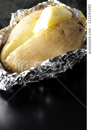 Hot buttered potatoes photographed against a black background 122141895
