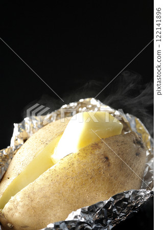 Hot buttered potatoes photographed against a black background 122141896