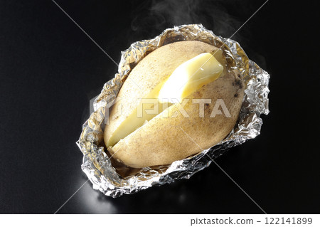 Hot buttered potatoes photographed against a black background 122141899