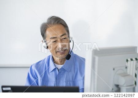 Senior male call center operator image wearing work clothes with a headset 122142097