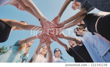 High school students come together in a circle, showing unity, teamwork, and collaboration during their summer break 122142136