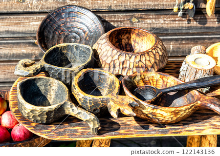 Unusual handmade wooden tableware. Utensils made of solid wood, selective focus Unusual handmade wooden tableware. Utensils made of solid wood, selective focus 122143136