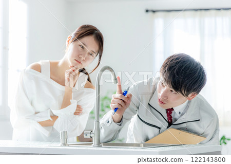 A man in work clothes and a young woman who is worried 122143800