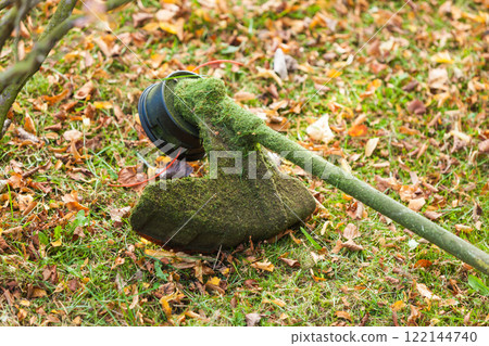 Mower brushcutter on green grass 122144740