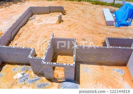 Preparing, laying concrete blocks for foundation of new building at construction site. 122144819
