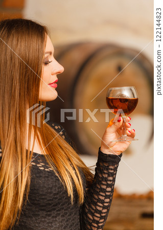 Woman tasting wine in rural cottage interior 122144823