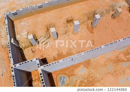 Foundation work underway with concrete blocks arranged for building in construction project Foundation work underway with concrete blocks arranged for building in construction project 122144860