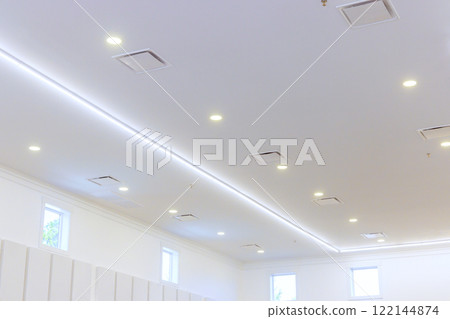 Bright, modern indoor space featuring well designed ceiling with multiple light fixtures soft ambient light. 122144874