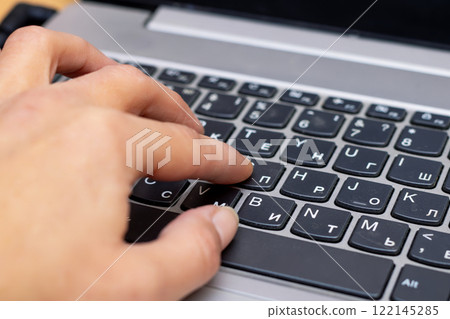 A close up image of a persons hand actively typing on a laptop keyboard A close up image of a persons hand actively typing on a laptop keyboard 122145285