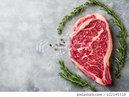 Raw wagyu rib eye steak with rosemary and pepper on kitchen table top.Macro.AI Generative. Raw wagyu rib eye steak with rosemary and pepper on kitchen table top.Macro.AI Generative. 122145510
