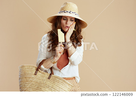 unhappy woman experiencing toothache isolated on beige 122146009