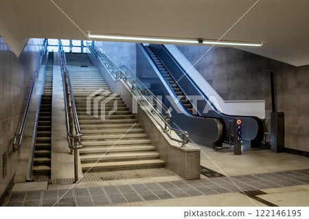 There is a set of stairs accompanied by escalators located within a building 122146195