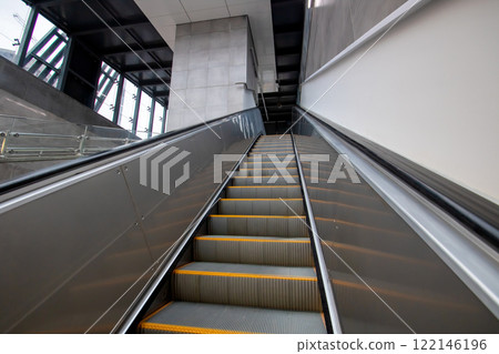 An escalator featuring bright yellow steps that move both upward and downward 122146196