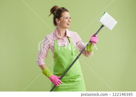smiling woman in green apron and rubber gloves on green 122146395