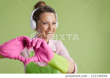 happy 40 years old woman showing heart hands isolated on green 122146400