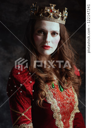 medieval queen in red dress with white makeup and crown 122147241