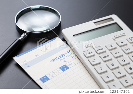 Time card, magnifying glass and calculator on black background 122147361
