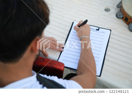 Man Studying Accordion And Watching On The Paper Man Studying Accordion And Watching On The Paper 122148121