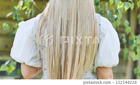 Blonde haired woman wearing traditional germanic attire, long tresses cascading down her back Blonde haired woman wearing traditional germanic attire, long tresses cascading down her back 122148228