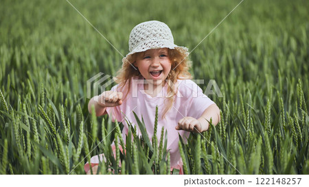 Cute little girl with blond hair and straw hat having fun in a wheat field, enjoying a sunny summer day Cute little girl with blond hair and straw hat having fun in a wheat field, enjoying a sunny summer day 122148257