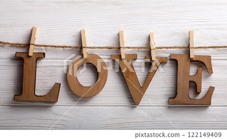 Wooden Letters Spelling Love Attached to a Rope with Clothespins 122149409