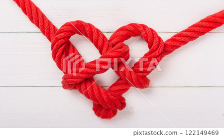 Red Rope Forming Heart Shape on White Wooden Background Red Rope Forming Heart Shape on White Wooden Background 122149469