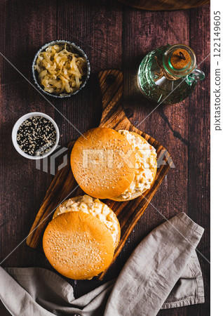 Salad burger with eggs, tomatoes, garlic and cheese on a board on a table top and vertical view 122149605