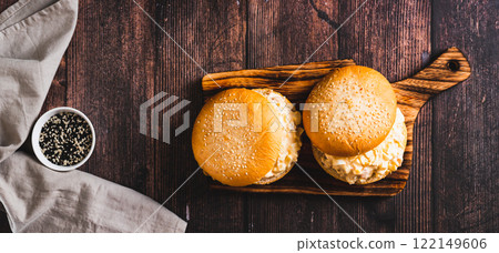 Salad burger with eggs, tomatoes, garlic and cheese on a board on a table top view web banner 122149606