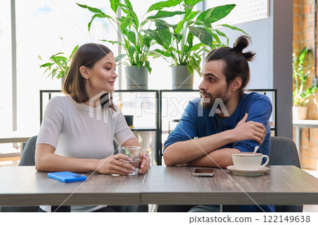 Young couple sitting talking together inside cafe 122149638