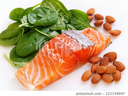 Well balanced diet with salmon and fresh spinach with raw almond nuts on light background.Macro.AI Generative. 122149897