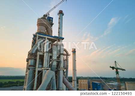 Cement plant with high factory structure and tower cranes at industrial production area. Manufacture and global industry concept 122150493