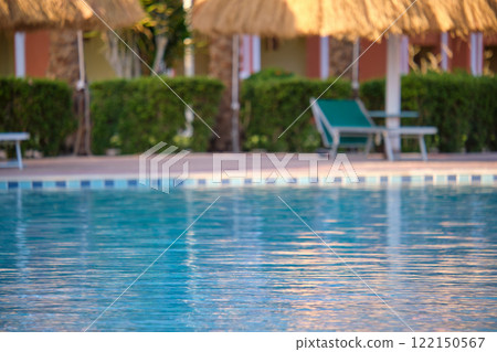 Blue clear water with small ripple waves in swimming pool at tropical resort. Summer vacations concept. Blue clear water with small ripple waves in swimming pool at tropical resort. Summer vacations concept. 122150567