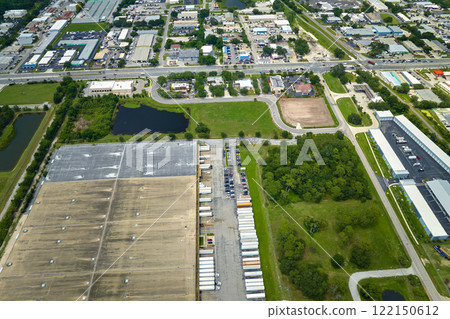 Big corporate shipment center with many cargo semi trucks unloading and uploading retail products for further retail shipment. Global market concept 122150612