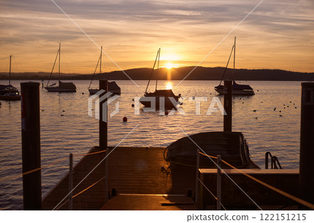 Pier at Sunset with Sailboats, Serene Lake Scene, Orange and Pink Sky, Calm Water, Silhouettes of Boats, Tranquil Evening, Reflections on Water, Peaceful Marina, Dusk Landscape, Nautical Atmosphere 122151215