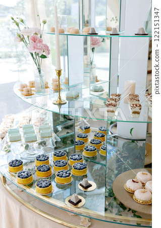 Delicious pastries and cakes decorating a glass tiered stand at a wedding reception 122151347