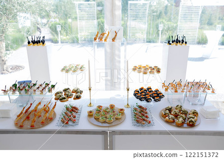 Catering service presenting finger food and appetizers on a table for a luxury event 122151372