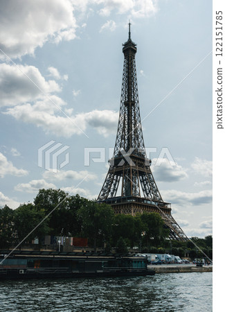 Eiffel tower under a cloudy sky with trees 122151785