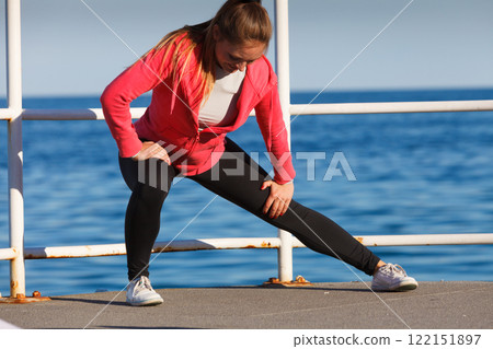 Woman doing sports exercises outdoors by seaside Woman doing sports exercises outdoors by seaside 122151897