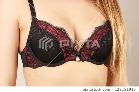 Woman in black bra lingerie taking care of her breasts 122151916