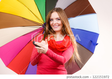 Woman standing under multicolored umbrella 122151972