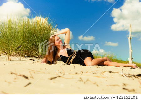 Woman sunbathing on beach. 122152101